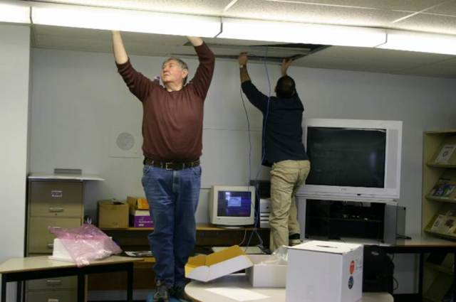 CDLI computers had to be networked. The equipment does not install itself. Yes, Frank has seen all the roofs from both sides, inside and outside. This time he's running Cat5 through a ceiling conduit.
